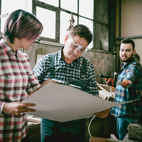 Two carpenters look over a plan.